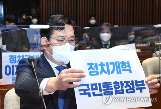 송영길 더불어민주당 대표가 27일 국회에서 열린 의원총회에서 '정치개혁 국민통합정부' 손피켓을 자리 앞에 놓고 있다. <연합뉴스>